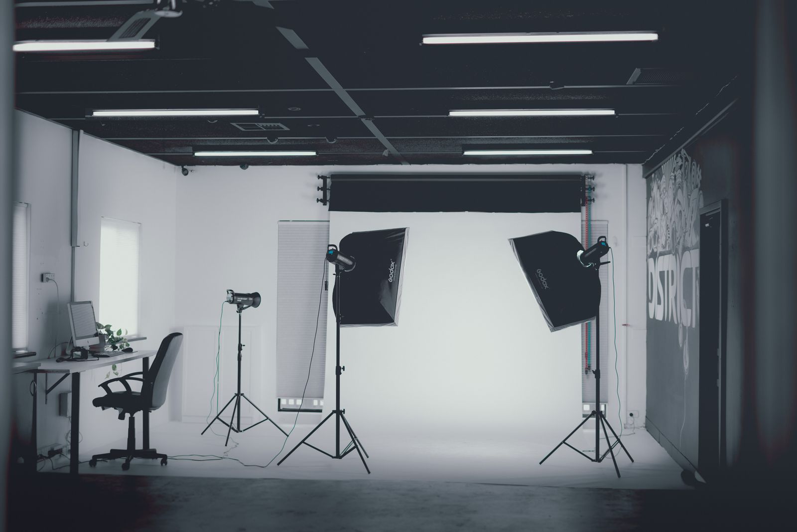 Grayscale interior of a professional photography studio with softbox lighting rigged for a shoot