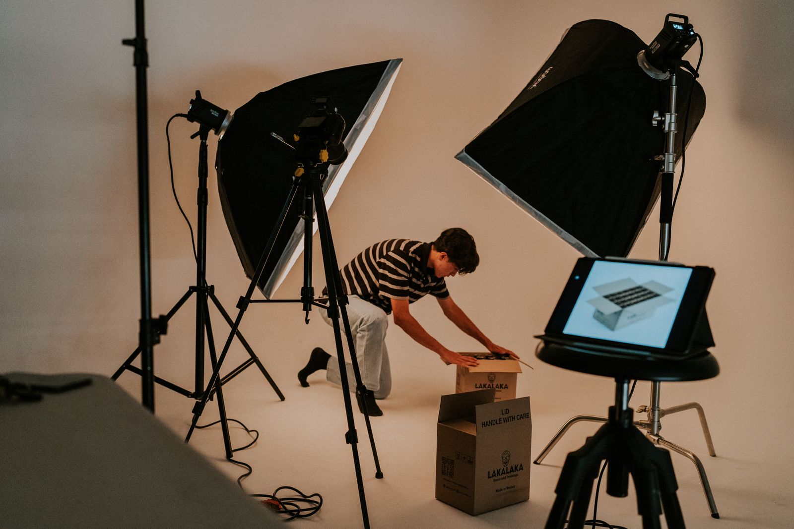 A stylist preparing packaging for a commercial product shoot under studio lighting