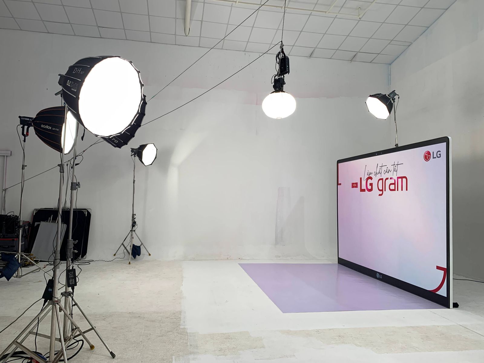 A modern commercial studio setup with softbox lighting and a laptop monitor
