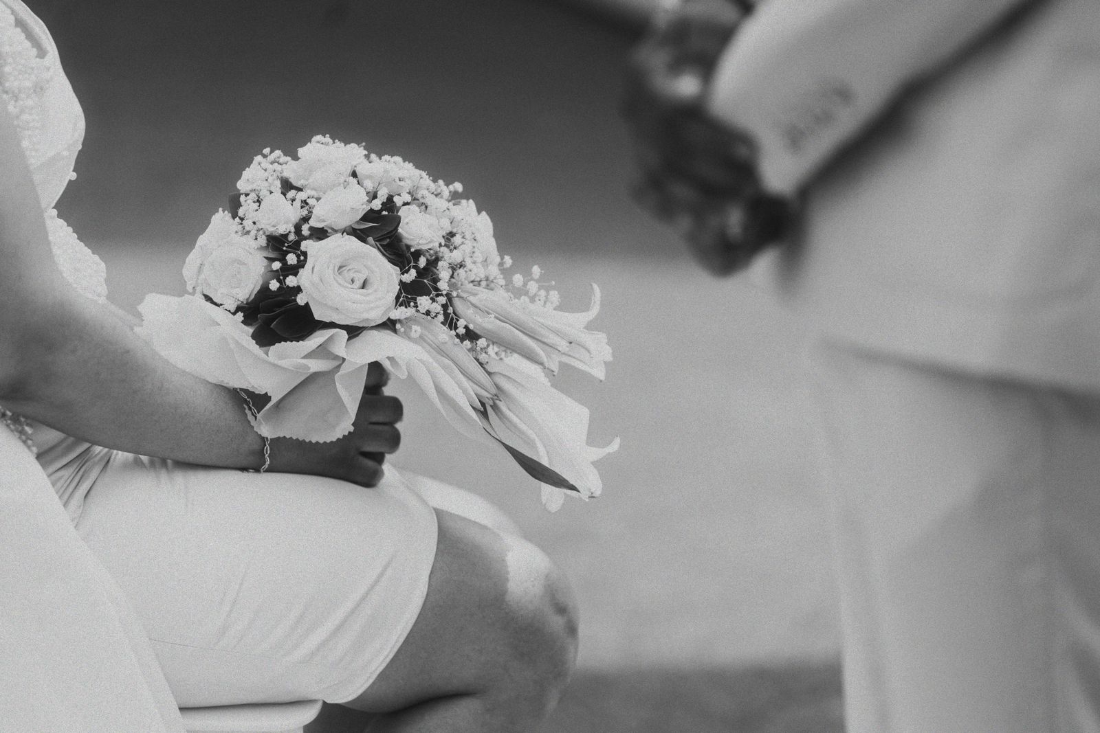 Close-up black and white shot of a bride holding her bouquet
