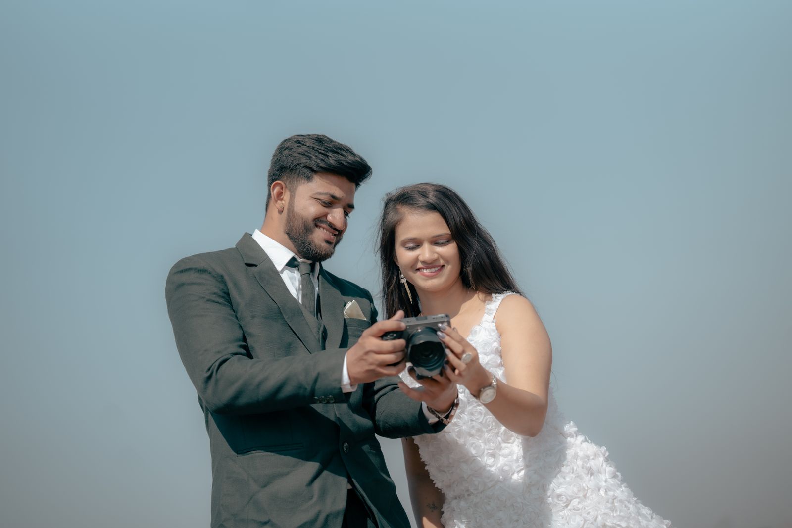 A couple reviewing photos together on a camera during a pre-wedding shoot